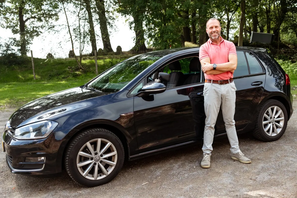 Jan Tienstra naast de auto